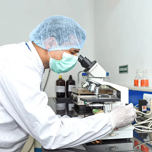 A man working in a laboratory with a microscope